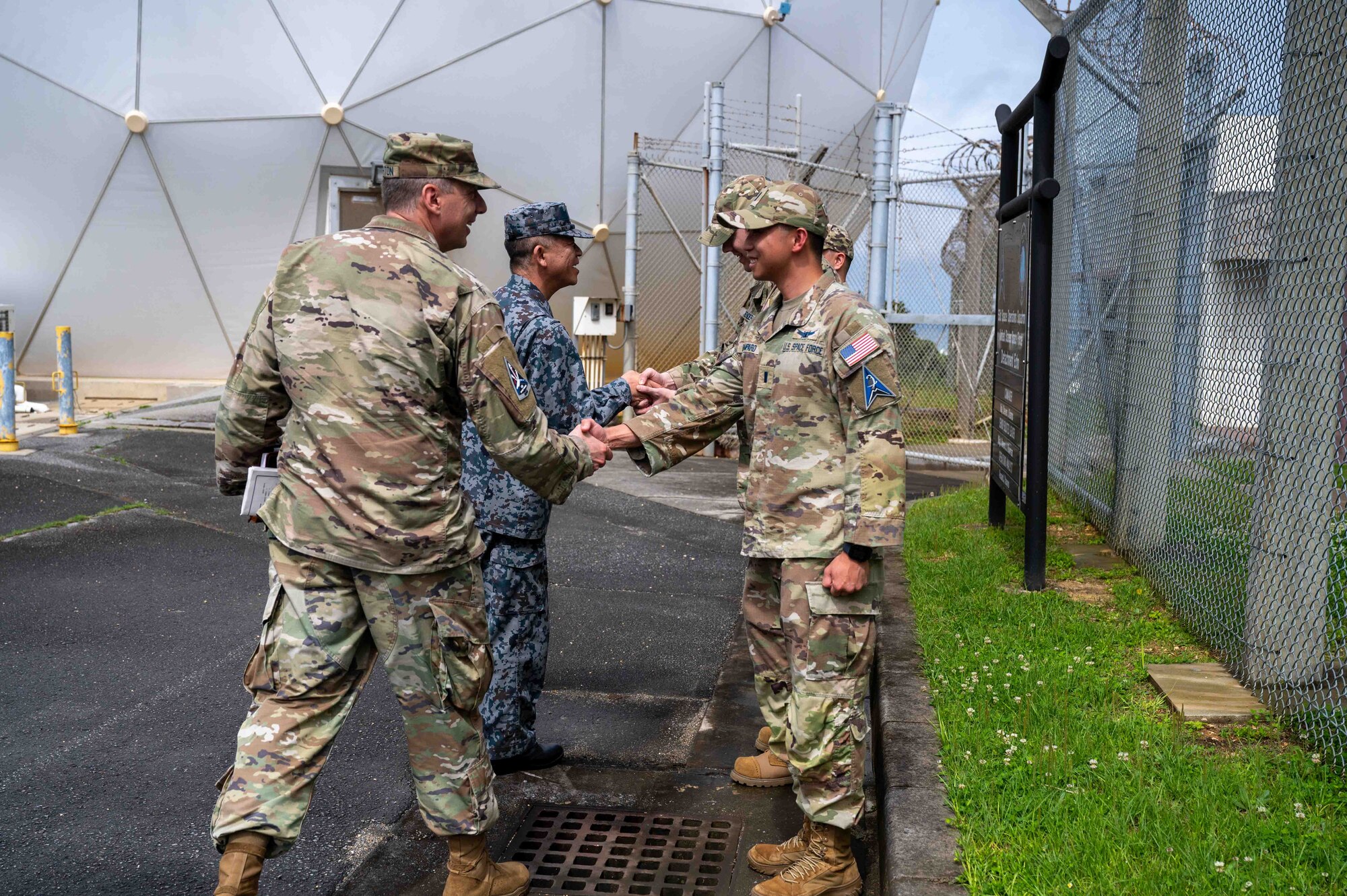 Service members shake hands and they get ready to tour the facility