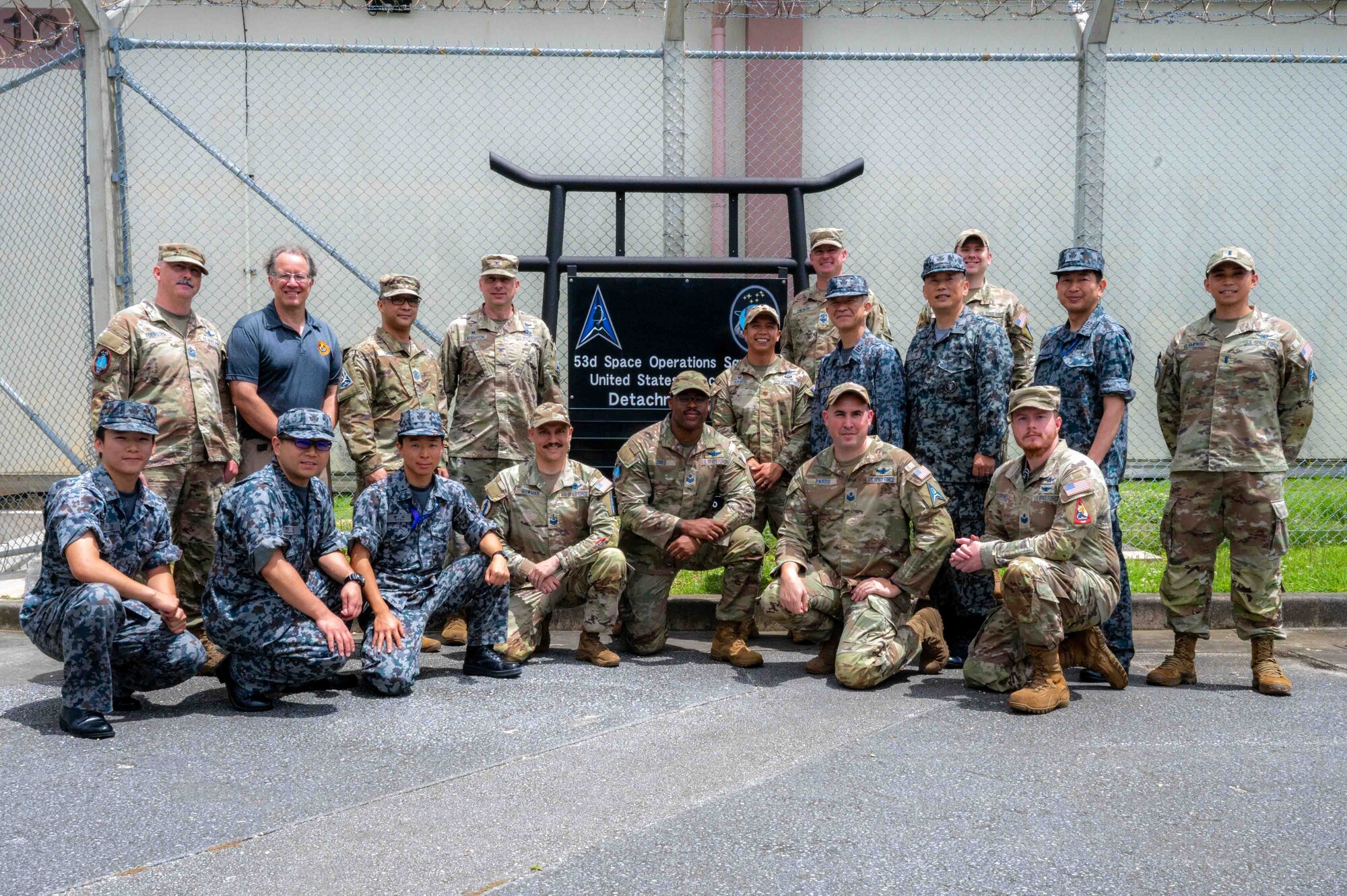 U.S. service members and Japanese service members pose for a group photo.