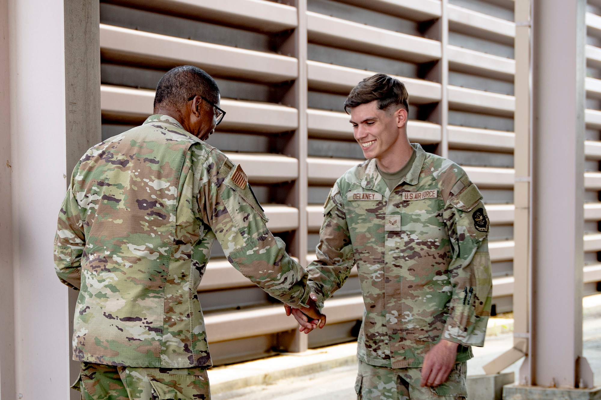 U.S. Air Force Senior Airman Jameson Delaney, 731st Air Mobility Squadron special handling technician, receives a coin from Gen. Randall Reed, U.S. Transportation Command commander, during his visit to Osan Air Base, Republic of Korea, June 10, 2025.