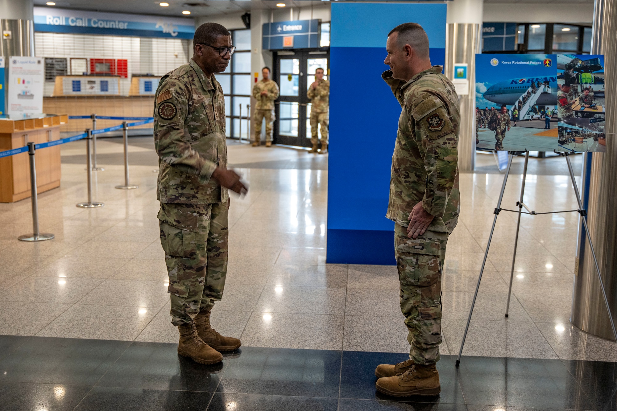 U.S. Air Force Staff Sgt. Tyler Webster, 731st Air Mobility Squadron passenger service supervisor, receives a coin from Gen. Randall Reed, U.S. Transportation Command commander, during his visit to Osan Air Base, Republic of Korea, June 10, 2025.