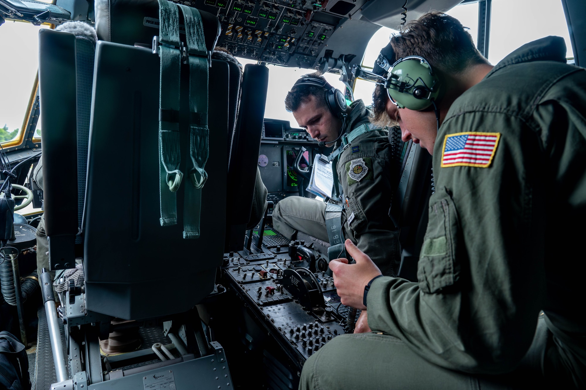 U.S. Air Force Capt. Thaad Franklin, 36th Airlift Squadron pilot, left, shows U.S. Air Force Academy Cadet Brendan Gibbons the control panel.