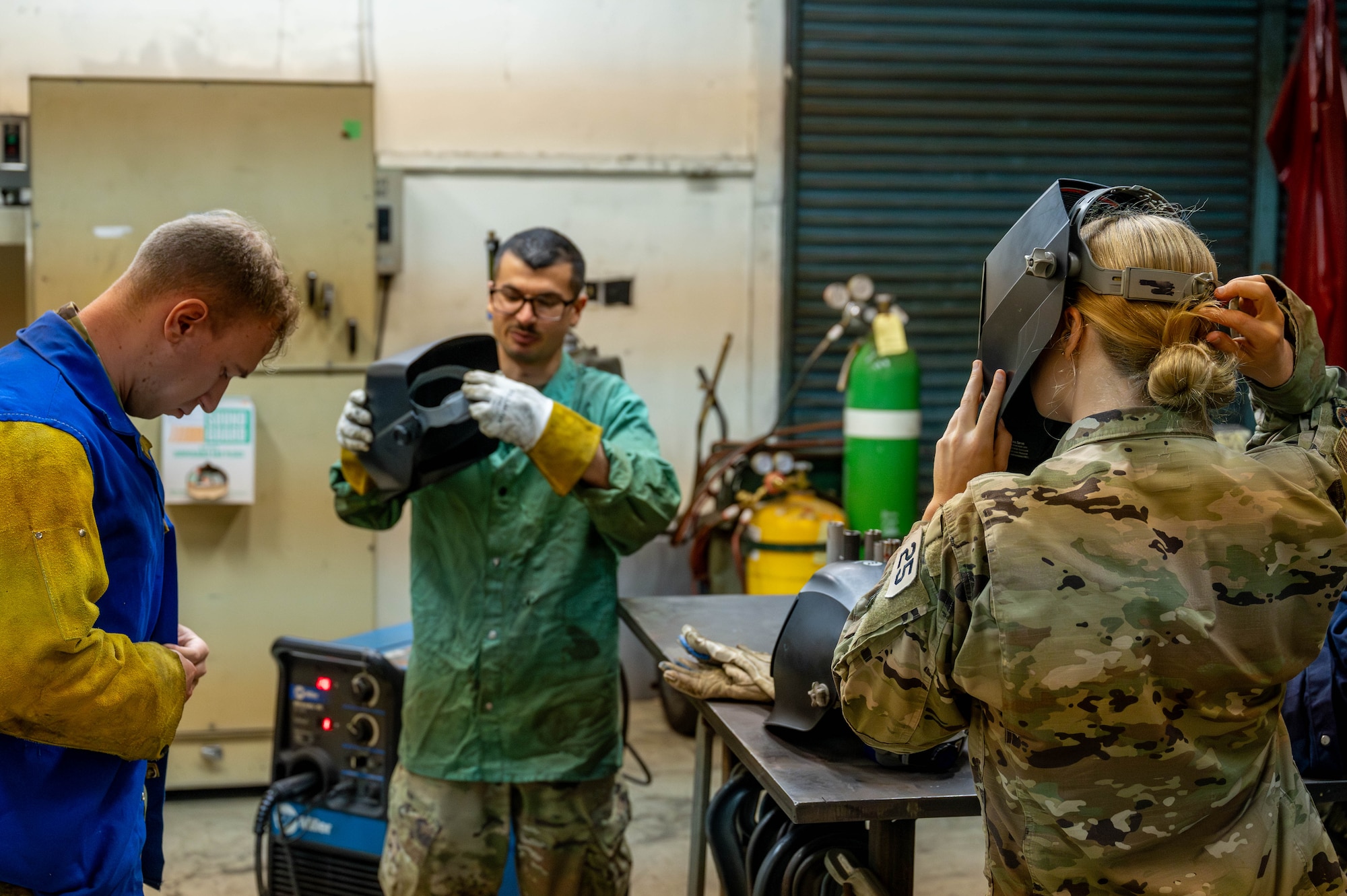 From left, U.S. Air Force Academy Cadet Dominick Lisitsin, U.S. Air Force Senior Airman Jacob Micallef, 374th Maintenance Squadron aircraft metals technology journeyman, and USAFA Cadet Katherine Frost, don protective gear.