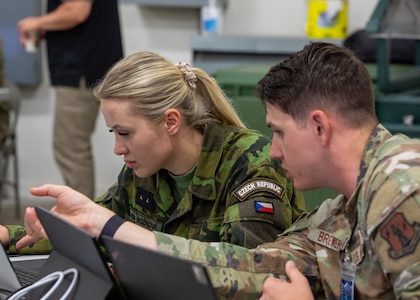 An Air National Guardsman and a Czech Republic military member collaborate together during exercise Cyber Shield 2025 in Virginia Beach, Virginia, June 9, 2025.