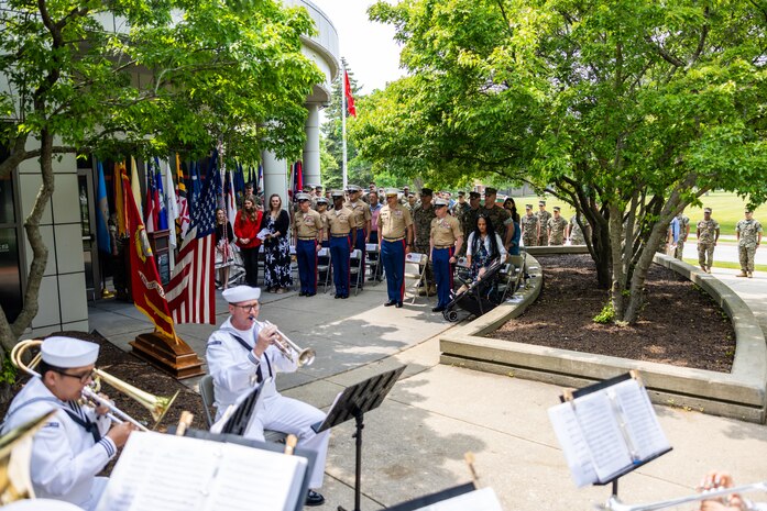 U.S. Marines with 9th Marine Corps District stand at attention for the playing of anchors’ aweigh during a post and relief ceremony at the 9th Marine Corps District Headquarters on Naval Station Great Lakes, Illinois, June 12, 2025. The ceremony  was held to mark the transition between senior enlisted leadership, signifying all responsibilities and authorities being transferred between the sergeants major. During the ceremony, Leader relinquished his post, and Sgt. Maj. Cory Curtis assumed his duties as the command’s senior enlisted leader. (U.S. Marine Corps photo by Cpl. Maxwell Cook)