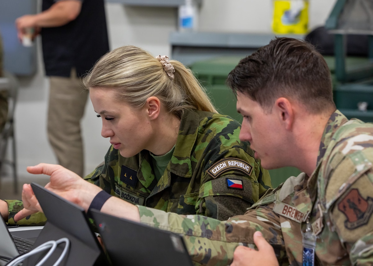 An Air National Guardsman and a Czech Republic military member collaborate together during exercise Cyber Shield 2025 in Virginia Beach, Virginia, June 9, 2025.