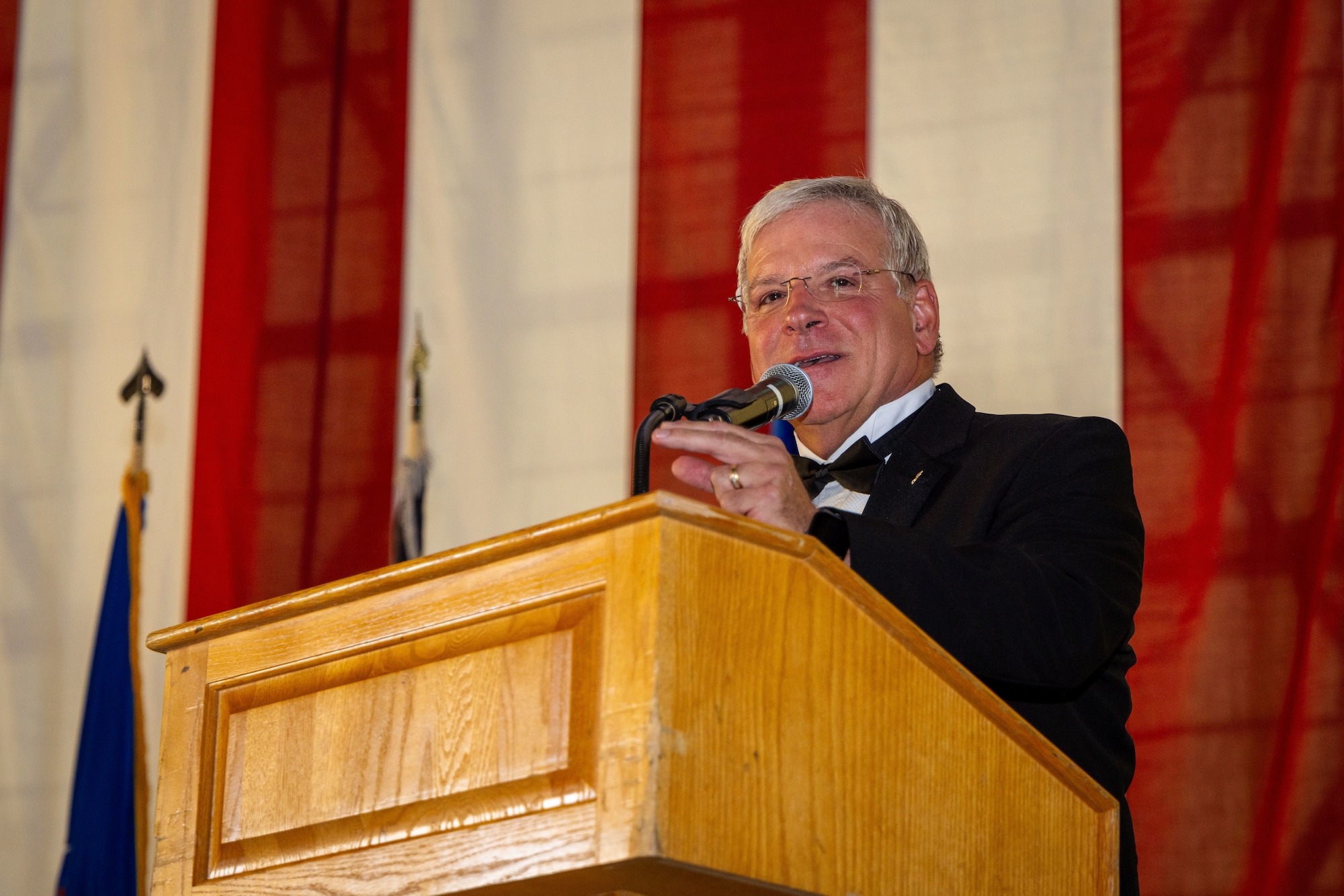 Air Force Test Pilot School alumni Roger Tanner, class 95-Alpha, speaks at the class 24-B graduation ceremony at Edwards Air Force Base, CA. Over the past 30 years, Mr. Tanner’s expertise in stall and spin testing has been a critical asset to the test enterprise. In 2001 he became the first Department of Defense civilian test pilot at Edwards Air Force Base. Since then, he has served as project pilot, safety and technical reviewer on numerous high angle of attack programs for the F-16, F-22, F-35, F-15 and T-7 aircraft. (Air Force photo by Brandon Hernandez)