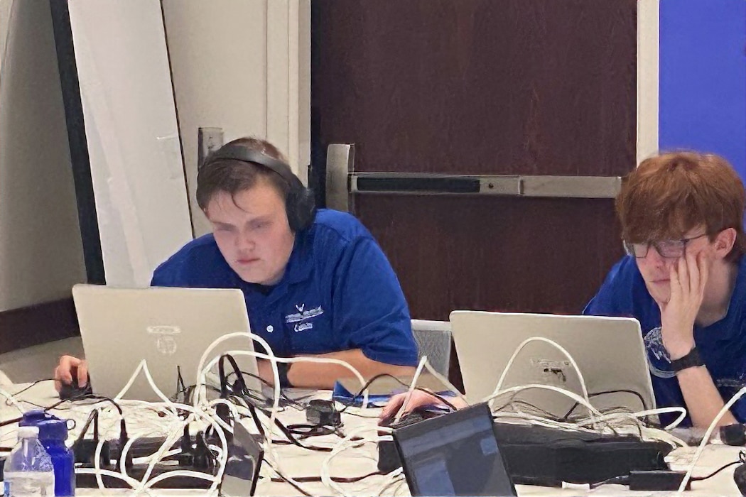 students sitting around a table filled with computers