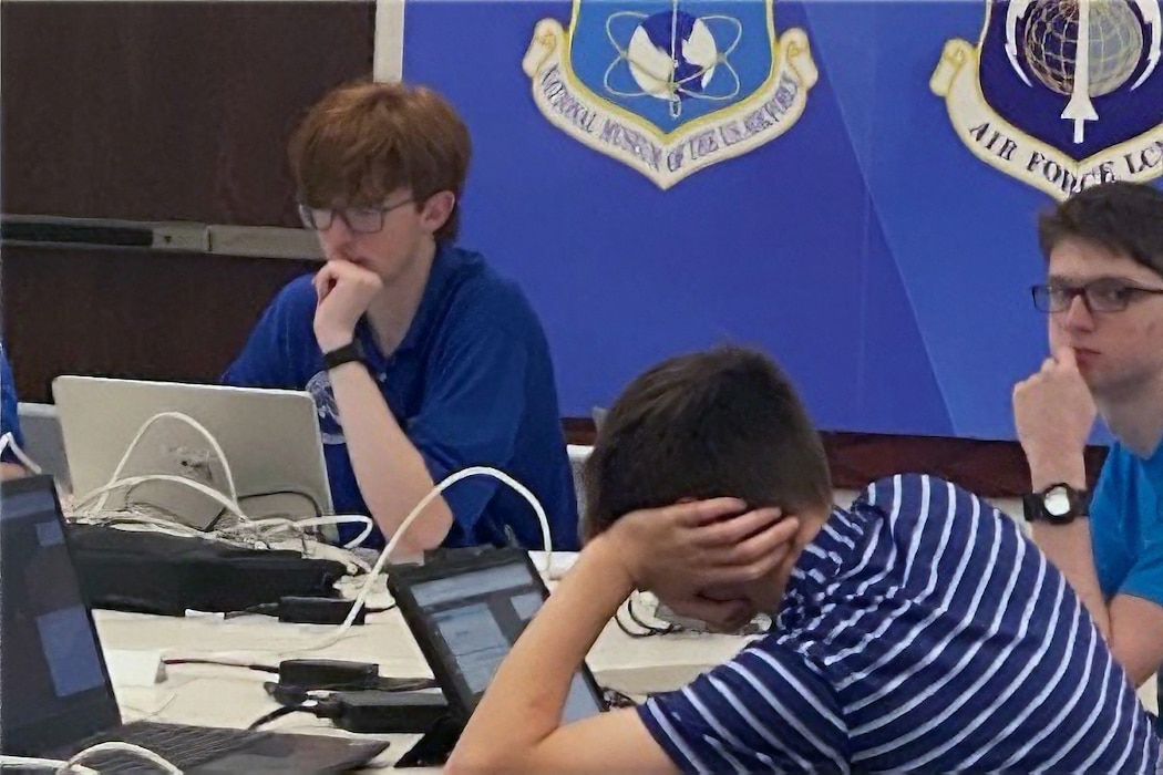 students sitting around a table filled with computers