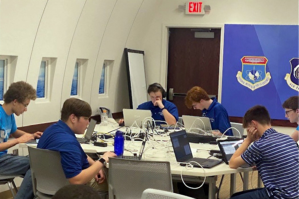 students sitting around a table filled with computers