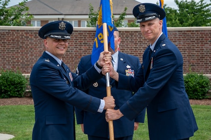 From left, U.S. Air Force Col. Patrick D. Rienzi, 844th Communications Group commander, bestows the guidon upon Lt. Col. Jeffrey P. Pelkey, 794th Communications Squadron incoming commander, during the 794th CS change of command ceremony at Joint Base Anacostia-Bolling, Washington, D.C., June 10, 2025. Pelkey previously served as the branch chief of 17D Talent Management, Headquarters Air Force at the Pentagon. (U.S. Air Force photo by Hayden Hallman)