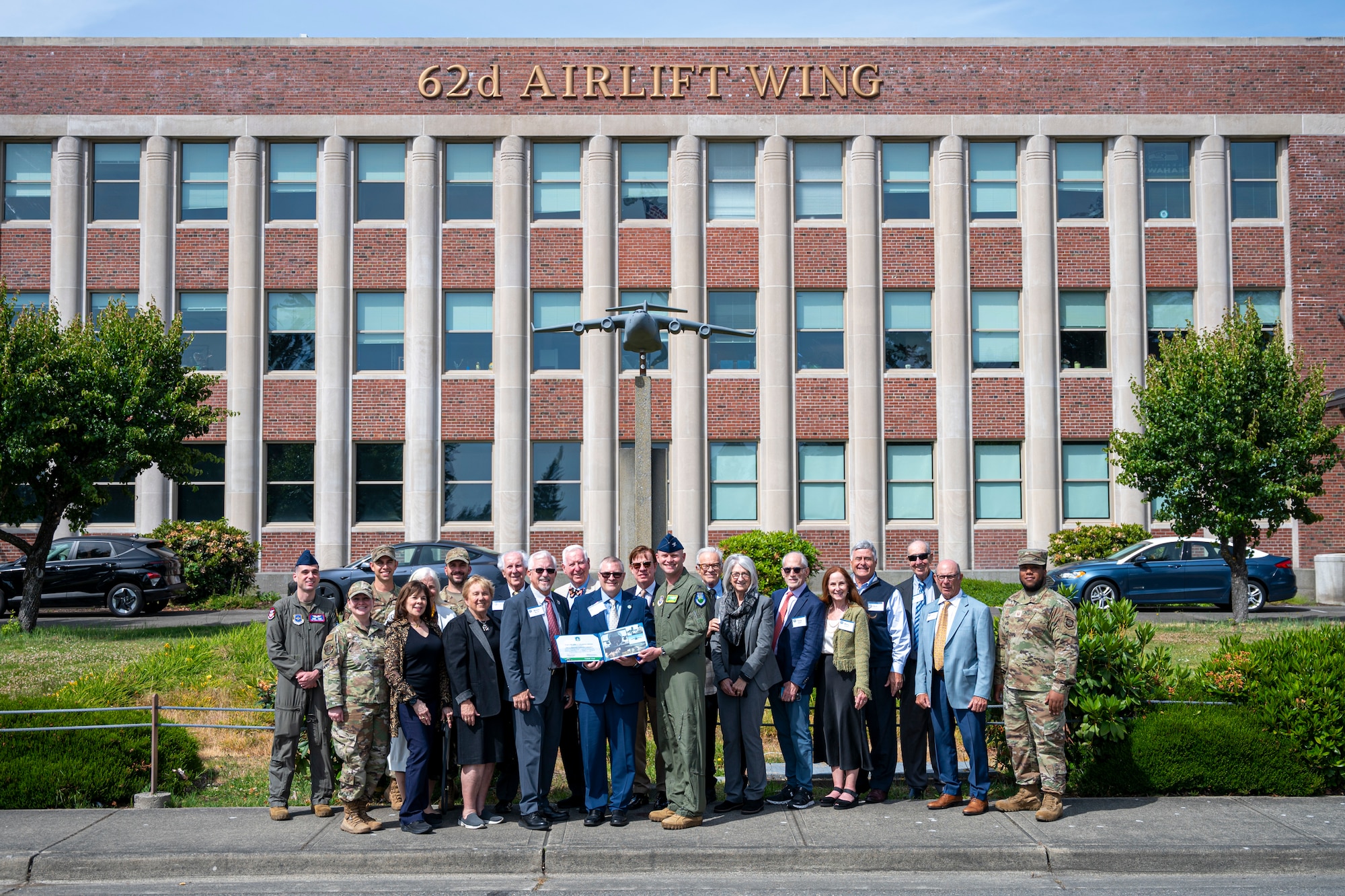 Members of the Defense Orientation Conference Association and Team McChord Airmen stand together in front of the 62d Airlift Wing headquarters at Joint Base Lewis-McChord, Washington, June 11, 2025.