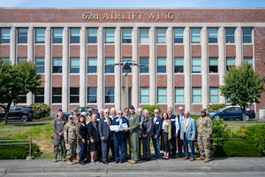 Members of the Defense Orientation Conference Association and Team McChord Airmen stand together in front of the 62d Airlift Wing headquarters at Joint Base Lewis-McChord, Washington, June 11, 2025.