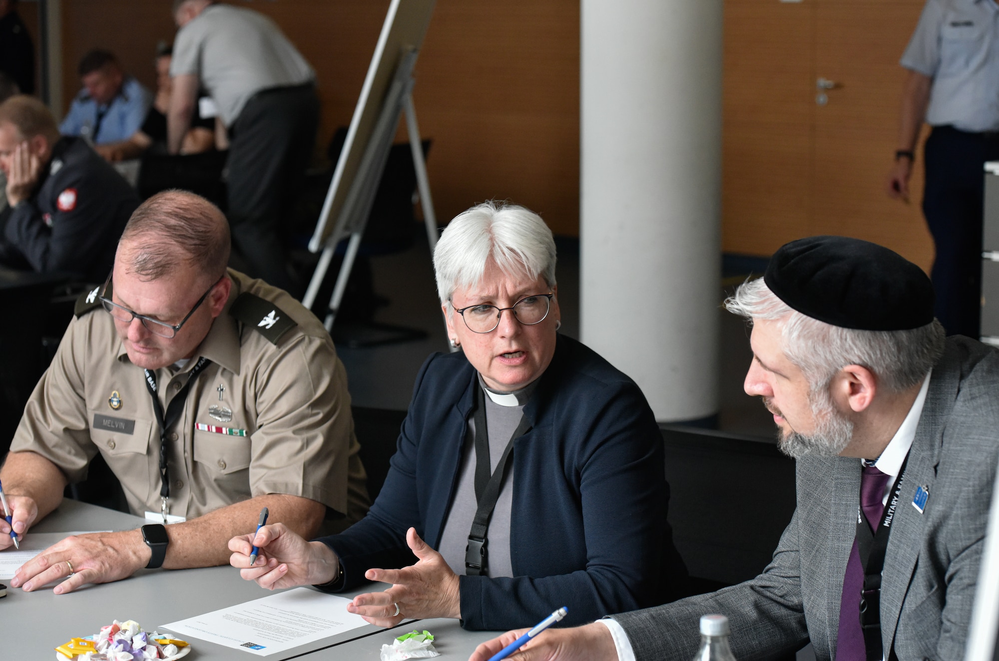 U.S. Army Chaplain (Col.) Chris Melvin, 10th Army Air and Missile Defense Command Chaplain, left, Dr. Alexandra Dierks, senior chaplain in the German Army, center, and David Friedrich Caeser, a chaplain in the German Army, participate in a tabletop exercise at the NATO Air Force Chaplains Consultative Committee Conference, Ramstein Air Base, Germany, June 10, 2025. Military chaplains from 12 NATO and partner nations across Europe convened at Ramstein for a conference to wargame how they might operate together in future conflicts. (U.S. Air Force photo by Capt. Cameron Silver)
