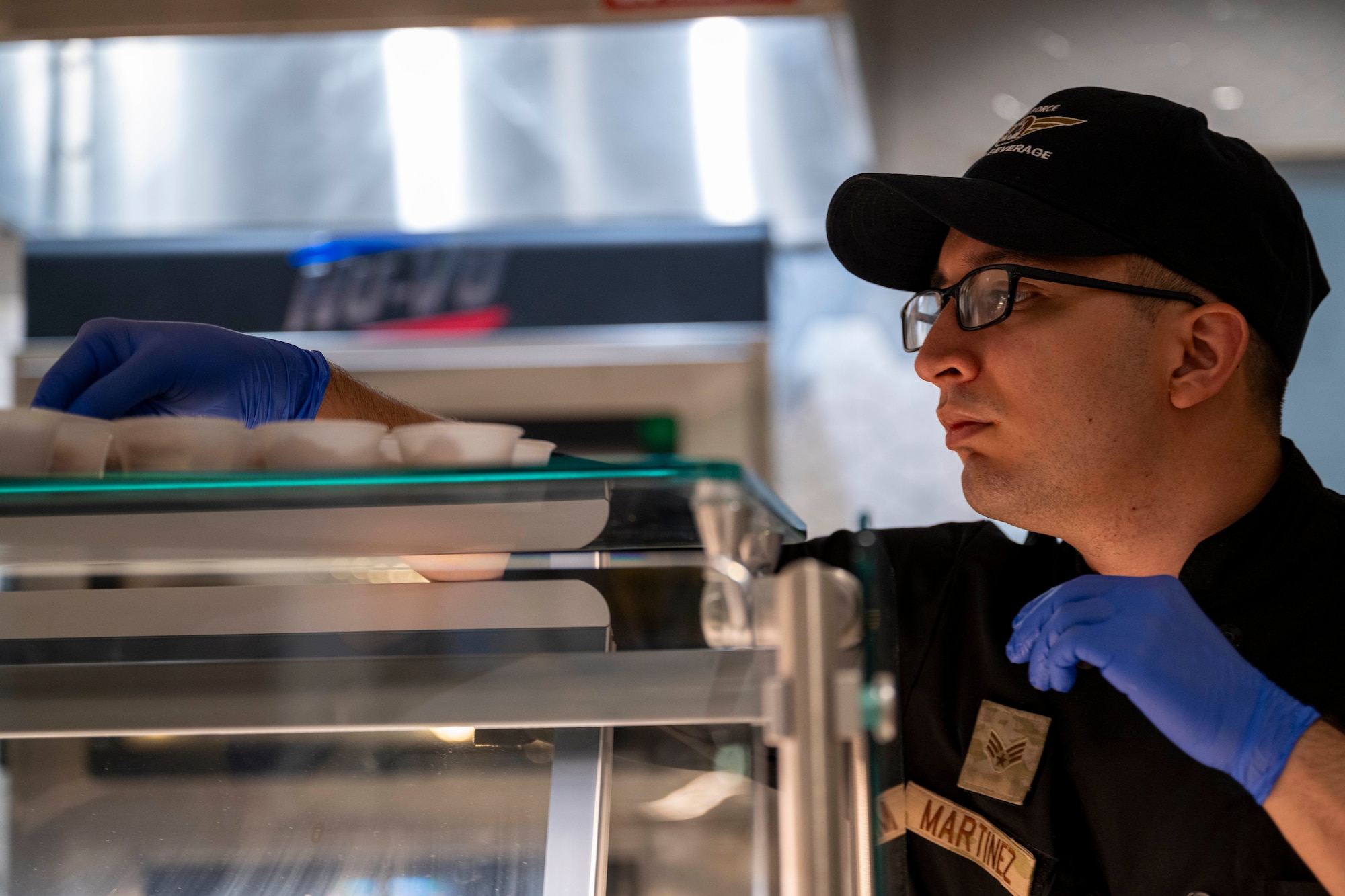 U.S. Air Force Senior Airman Alexander Martinez, 49th Force Support Squadron food service journeyman, sets out samplers during the Shifting Sands Dining Facility grand reopening ceremony at Holloman Air Force Base, New Mexico, June 12, 2025.