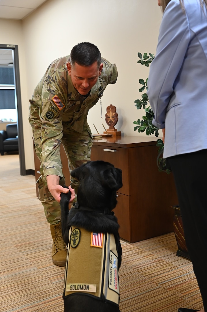 Photo of CRDAMC's Facility Dog Solomon with the Commander