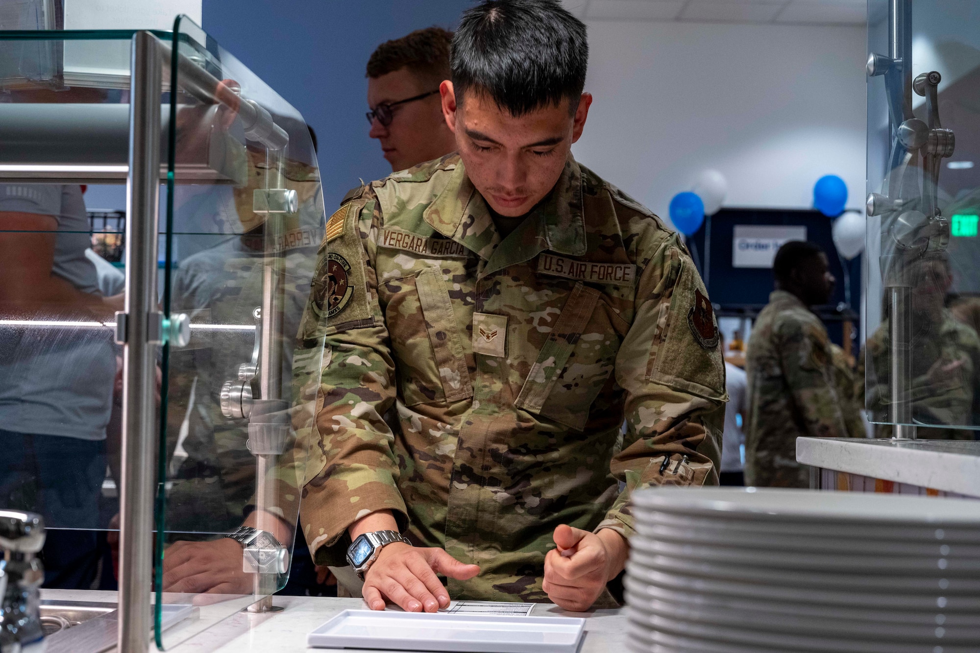 U.S. Air Force Airman 1st Class Alexander Vergara Garcia, 849th Aircraft Maintenance Squadron F-16 avionics apprentice, fills out an order ticket during the Shifting Sands Dining Facility grand reopening ceremony at Holloman Air Force Base, New Mexico, June 12, 2025.