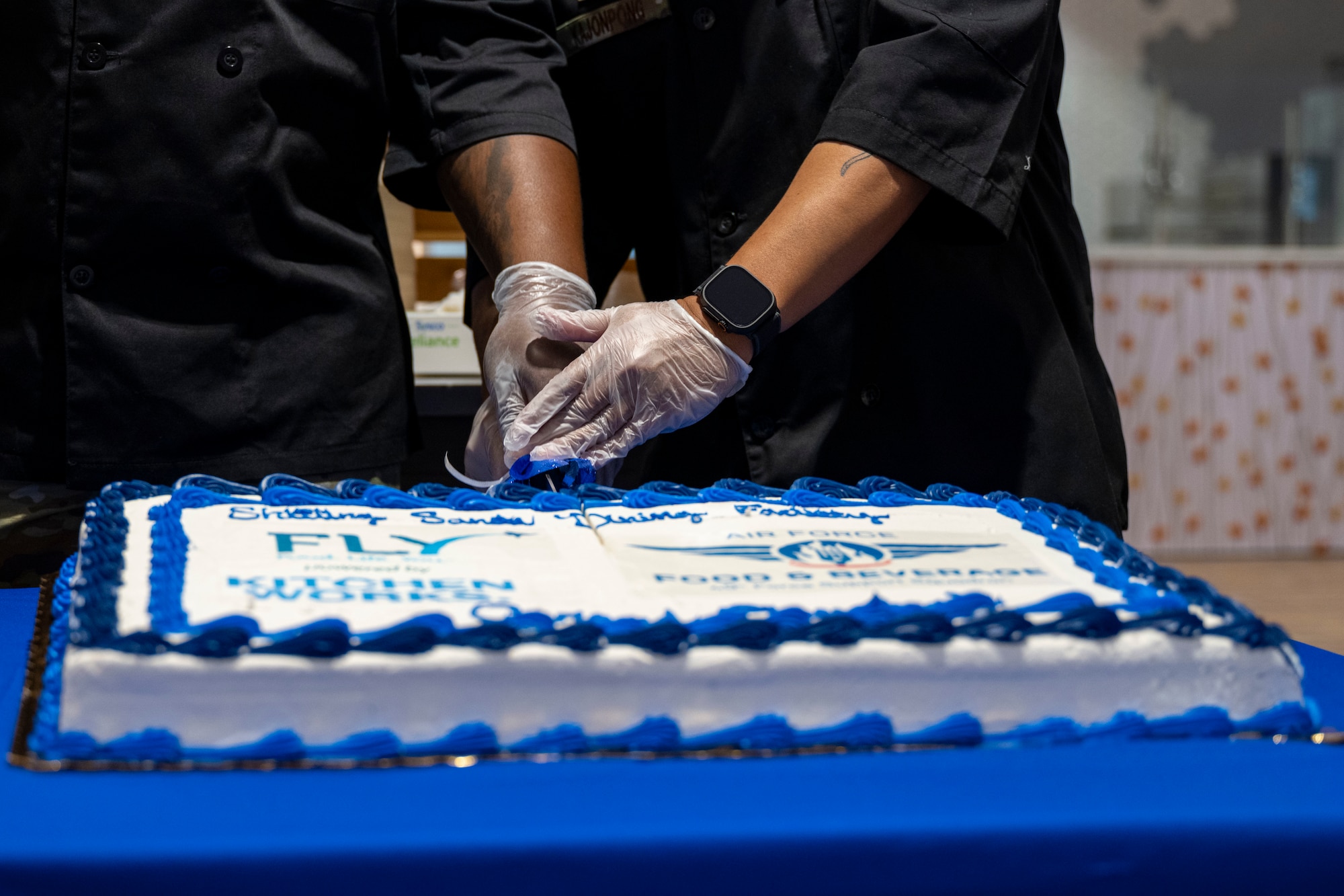 Members of the 49th Force Support Squadron cut a cake during the Shifting Sands Dining Facility grand reopening ceremony at Holloman Air Force Base, New Mexico, June 12, 2025.
