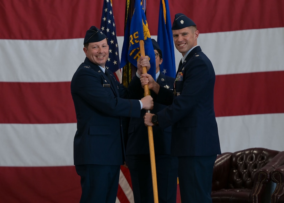 U.S. Air Force Lt. Col. Brandon DeLong, outgoing 312th Training Squadron commander, passes the guidon to Col. Jason Gerber, 17th Training Group commander, relinquishing command during the change of command ceremony at the Louis F. Garland Department of Defense Fire Academy, Goodfellow Air Force Base, Texas, June 12, 2025. Passing the guidon represents the transfer of leadership responsibilities to the next commander. (U.S. Air Force photo by Senior Airman Evelyn J. D’Errico)