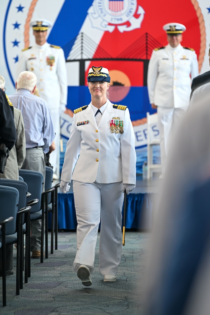 Capt. Courtney Sergent walks down the aisle following a change of command ceremony held at the Port of Tampa Bay in Tampa, Florida, June 13, 2025., where Sergent assumed command of the Sector. The Sector is one of the Coast Guard's largest commands, with an area of responsibility encompassing over 400 nautical miles of coastline along Florida's west coast and the third largest U.S. port for domestic trade. (U.S. Coast Guard photo by Petty Officer 1st Class Riley Perkofski)