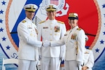 Capt. Michael Kahle (left) shakes hands with Capt. Courtney Sergent (right) during a change of command ceremony held at the Port of Tampa Bay in Tampa, Florida, June 13, 2025. Rear Adm. Douglas Schofield, commander of the Seventh Coast Guard District, presided over the ceremony. (U.S. Coast Guard photo by Petty Officer 1st Class Riley Perkofski)