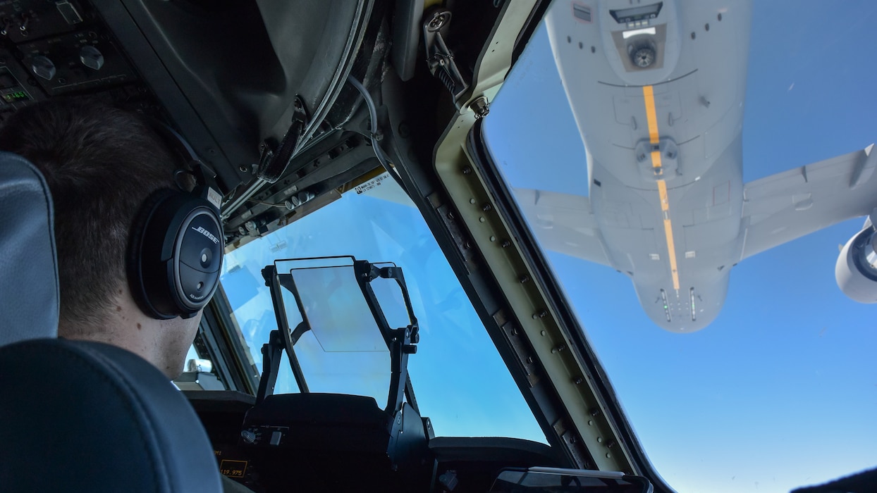 A pilot flies a C-17 to refuel with a KC-46