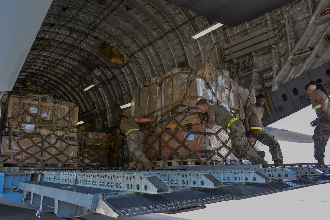 airmen push cargo onto aircraft
