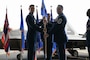 A USAF Colonel hands a guidon to a USAF command chief.