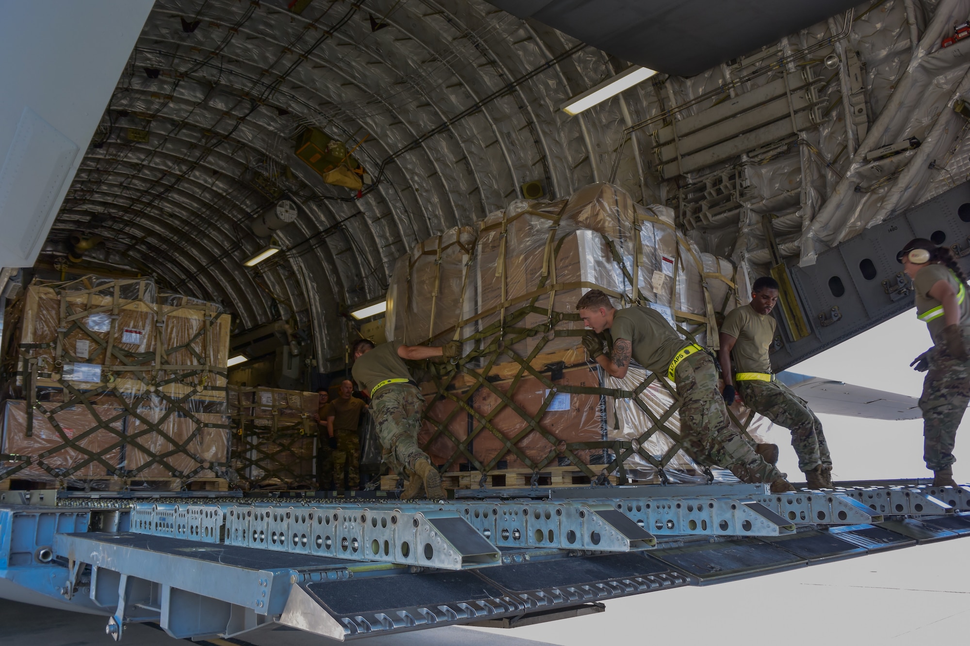 airmen push cargo onto aircraft