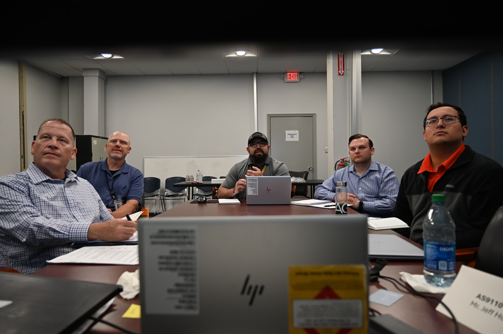 Several employees around a computer looking at a presentaion