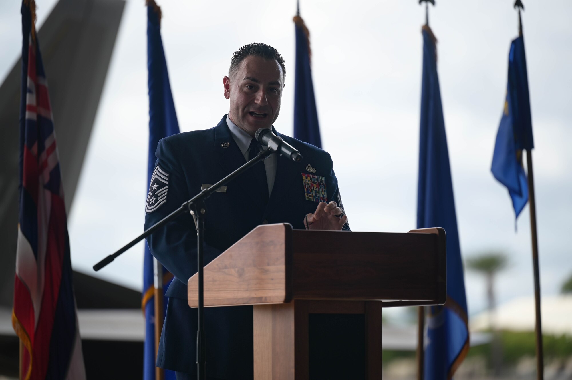A USAF command chief speaks at a podium.