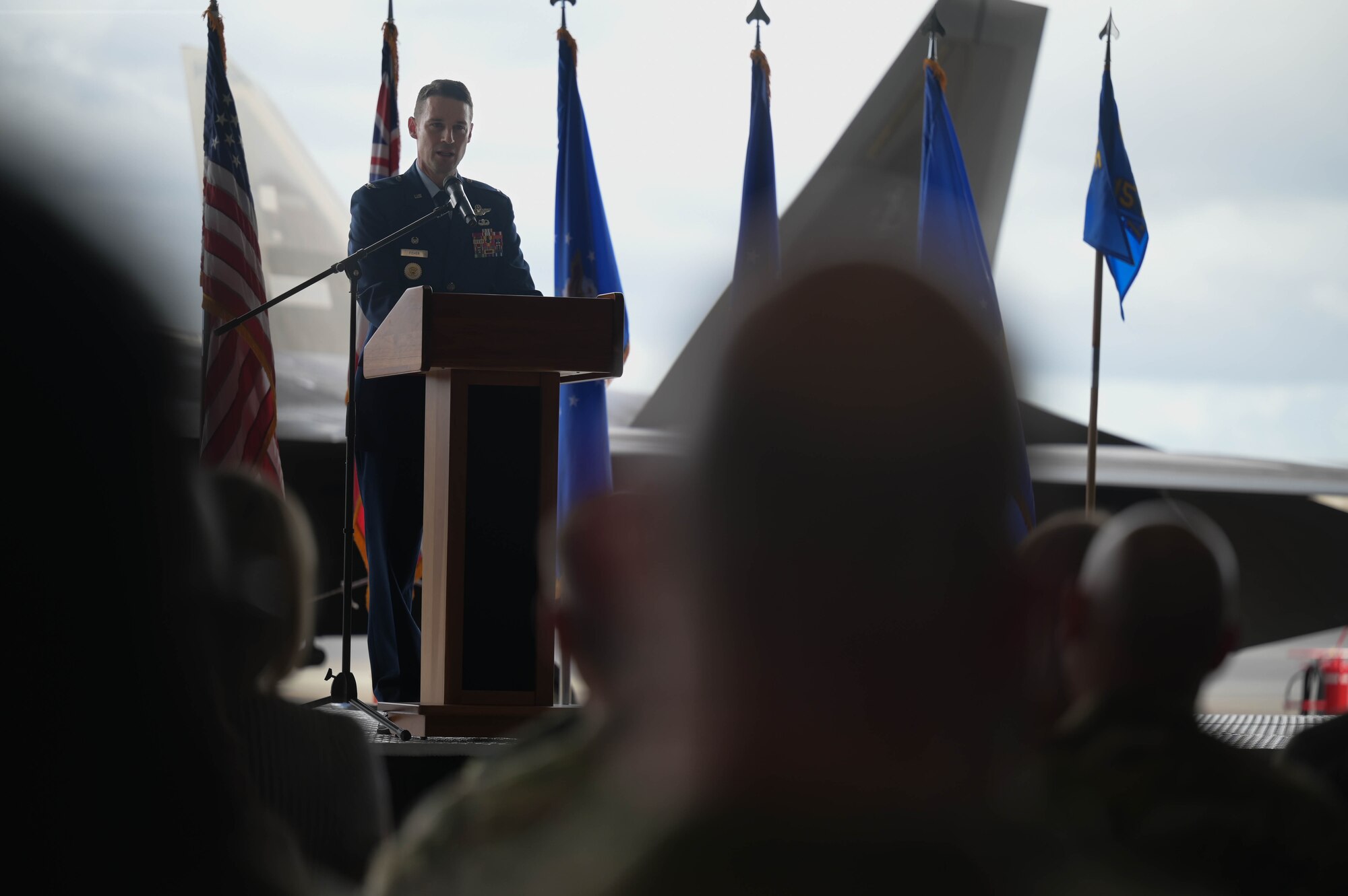 A USAF colonel speaks at a podium.