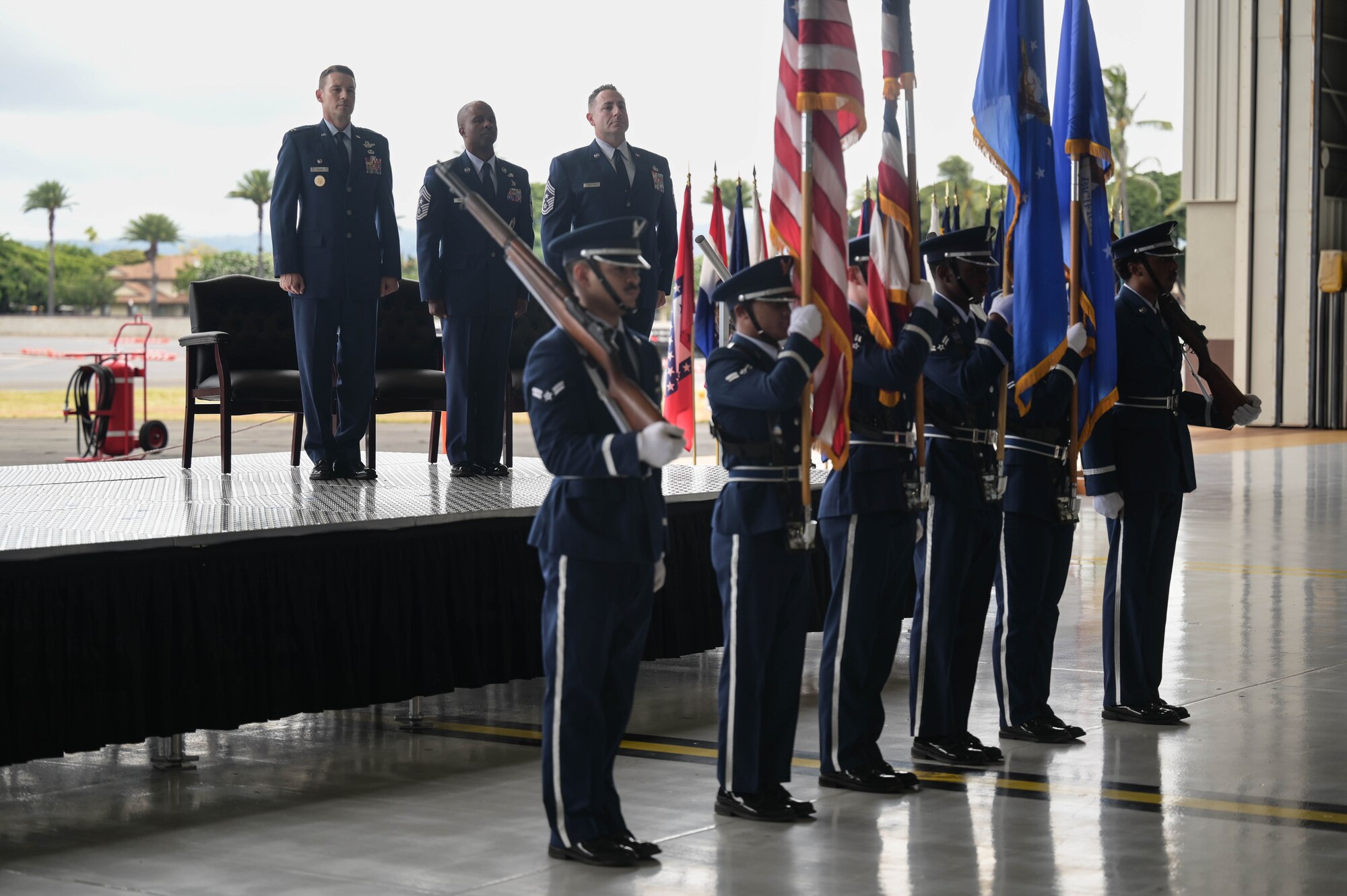 Honor Guard presents the colors inside of a hangar.