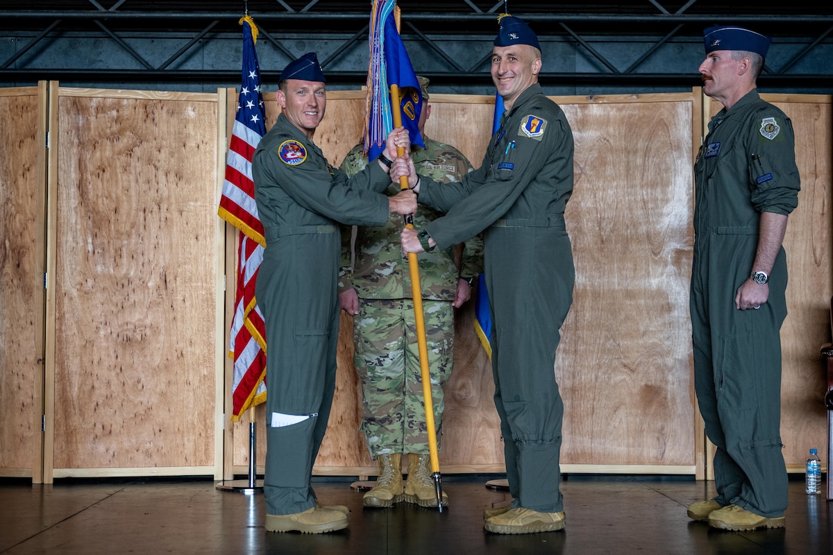 U.S. Air Force Col. Paul Davidson, left, 35th Fighter Wing commander, passes the group guidon to U.S. Air Force Col. Jeromy Guinther, incoming 35th Operations Group (OG) commander, during a change of command ceremony.
