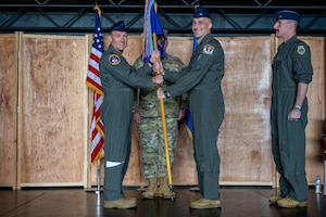 U.S. Air Force Col. Paul Davidson, left, 35th Fighter Wing commander, passes the group guidon to U.S. Air Force Col. Jeromy Guinther, incoming 35th Operations Group (OG) commander, during a change of command ceremony.