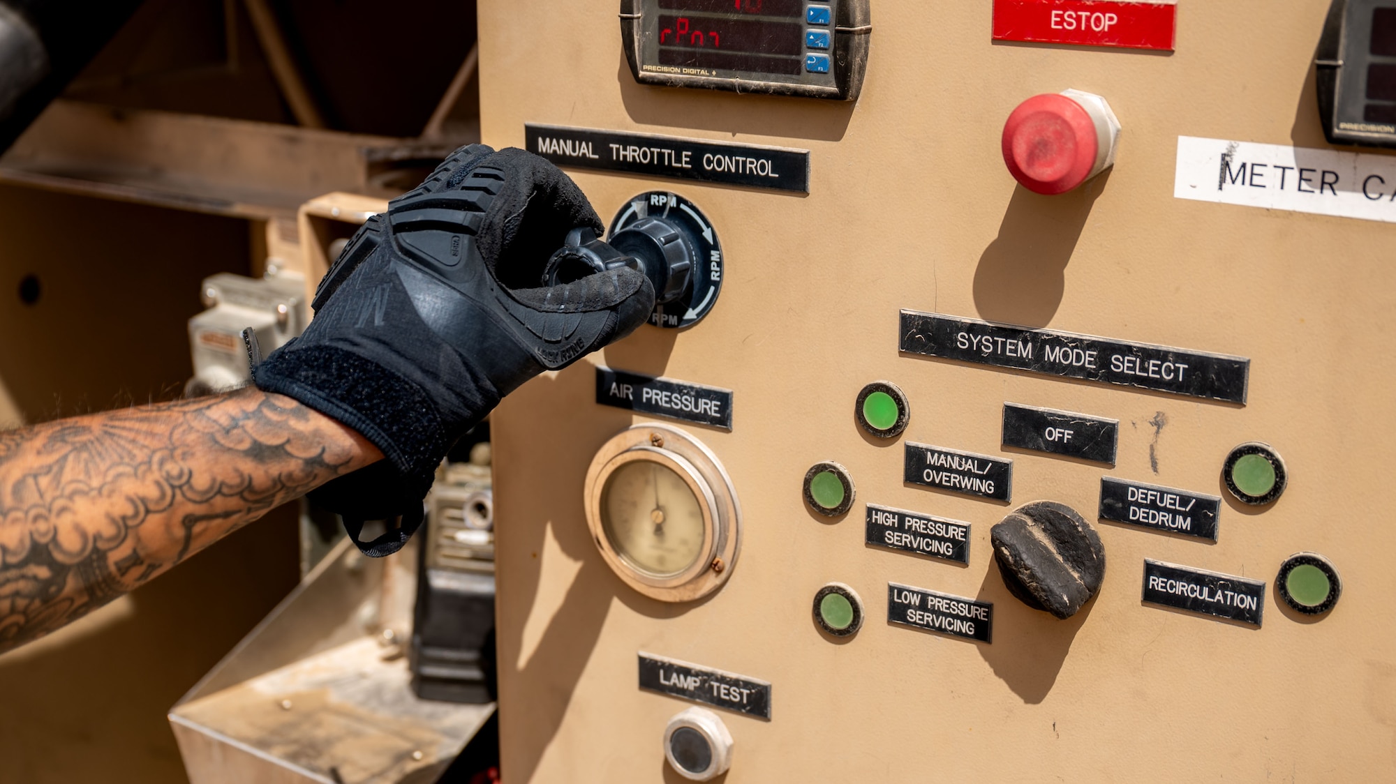 A hand adjusts a knob on a fuel truck.