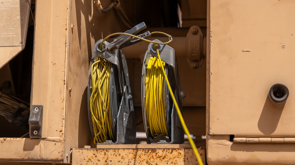 Two reels of cable sit on a fuel truck.