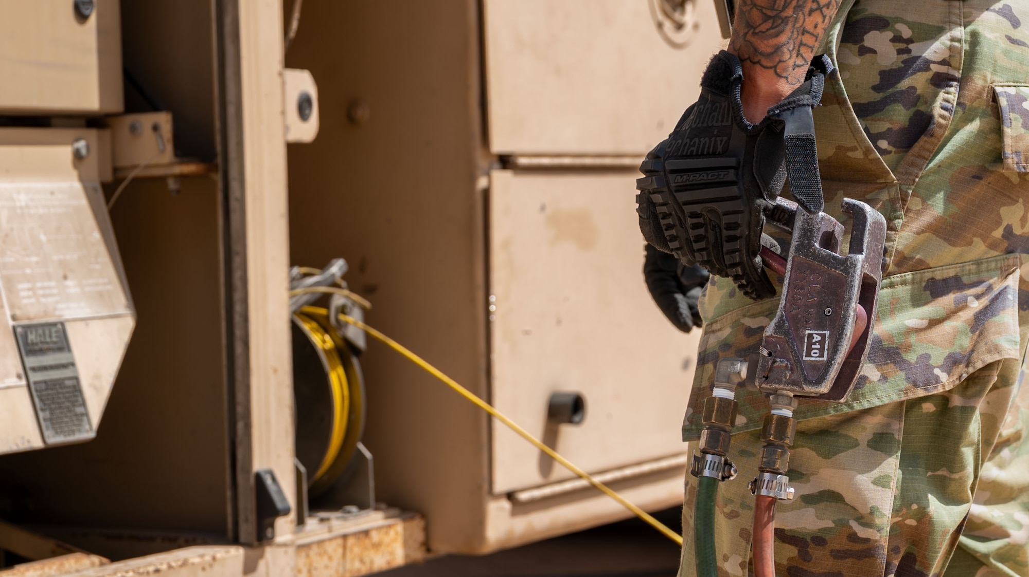 A close shot of a hand holding a lever connected to a fuel truck.