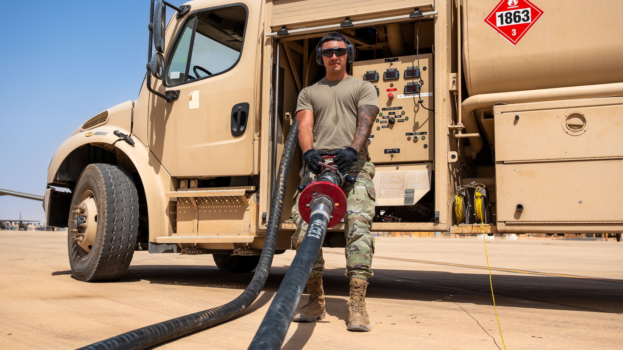 A man pulls in a fuel hose.