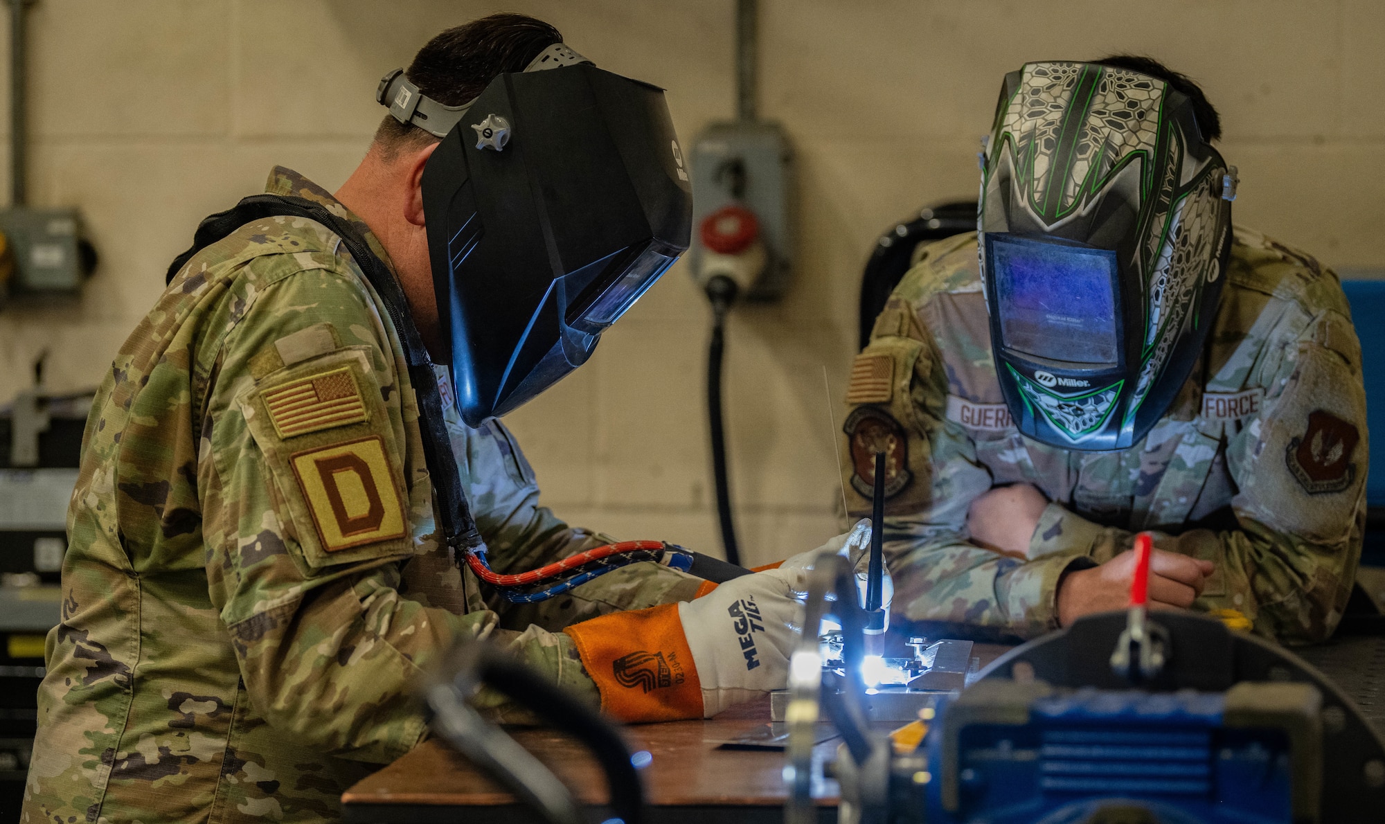 U.S. Air Force Col. Joseph Wall, left, 100th Air Refueling Wing deputy commander, and Senior Airman Coby Guerrero, 100th Maintenance Squadron metal technology journeyman, practice welding processes on pieces of stainless steel sheet metal for a non-destructive inspection during a Day in the Life immersion with the 100th MXS at RAF Mildenhall, England, June 13, 2025.