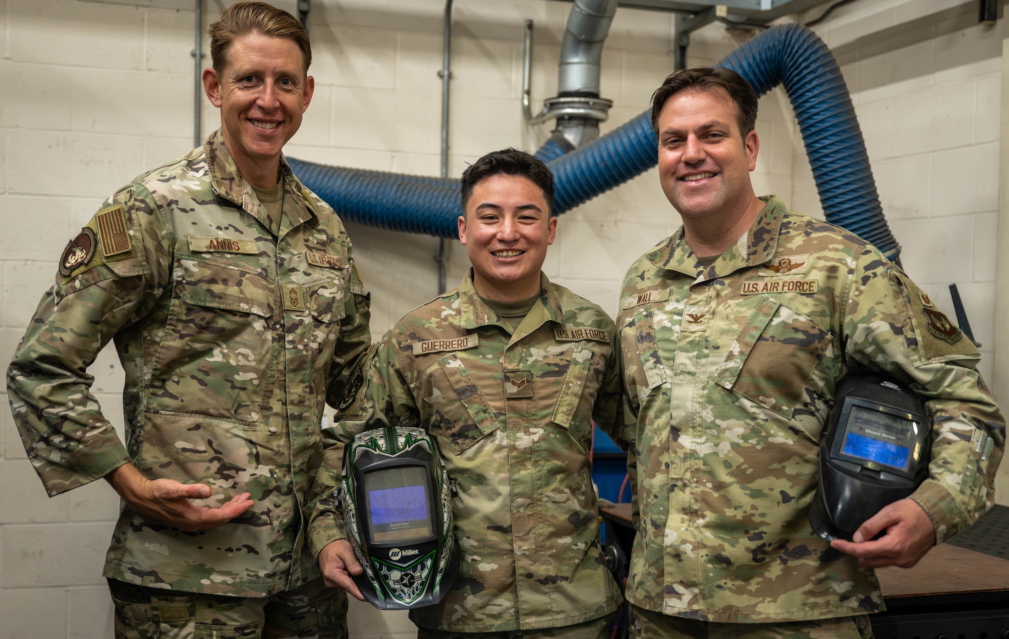 U.S. Air Force Col. Joseph Wall, right, 100th Air Refueling Wing deputy commander, Senior Airman Coby Guerrero, center, 100th Maintenance Squadron metal technology journeyman, and Chief Master Sgt. Markus Annis, 100th Communications Squadron senior enlisted leader, pose for a photo after a Day in the Life immersion with the 100th MXS at RAF Mildenhall, England, June 13, 2025.