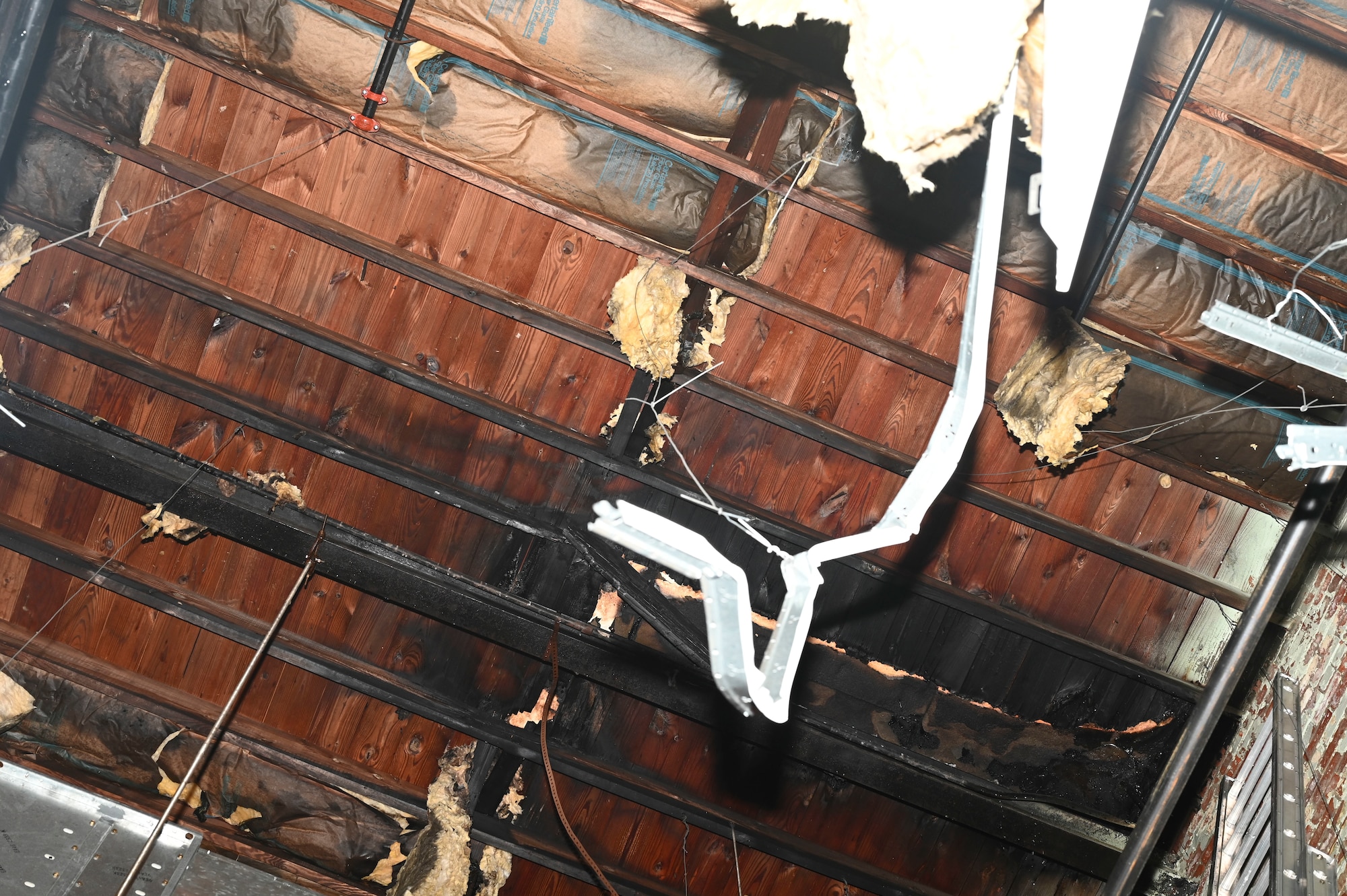 The decking of the roof and insulation in the 22nd Air Refueling Wing’s innovation lab is visibly damaged and burnt after a fire at McConnell Air Force Base, Kansas, June 3, 2025. The fire was discovered when Airmen responded to a carbon monoxide alarm that was triggered in the building. (U.S. Air Force photo by Senior Airman Paige Weldon)