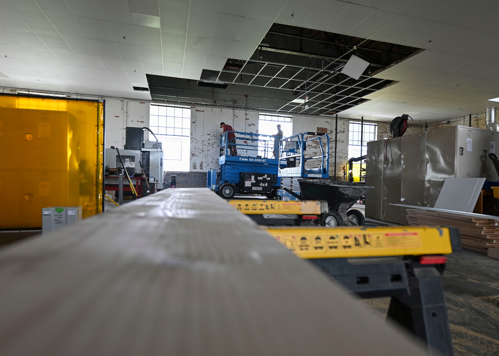 Civilians from the 22nd Civil Engineer Squadron position a scissor lift inside the 22nd Air Refueling Wing’s innovation lab at McConnell Air Force Base, Kansas, June 12, 2025. Repairs are expected to take one to two months, and upon completion, the lab will be fully operational again. (U.S. Air Force photo by Senior Airman Paige Weldon)