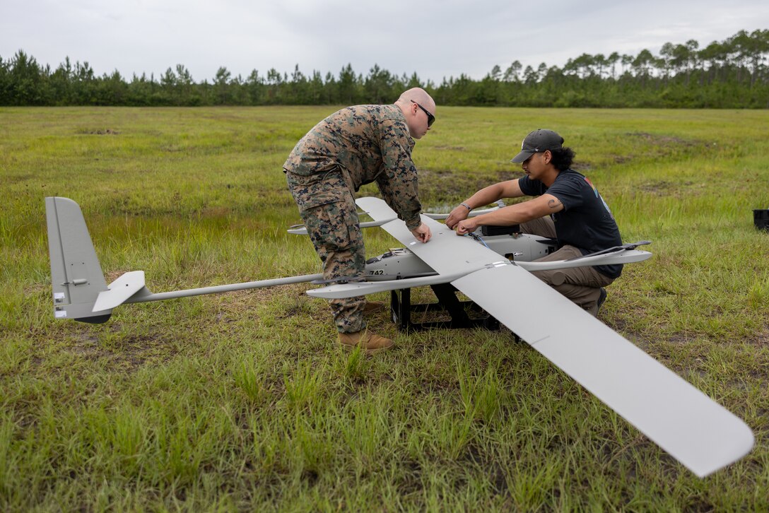 U.S. Marine Corps Cpl. Duane Hearn II, a recon surveillance target acquisition trainer with 2nd Light Armored Reconnaissance, Battalion Landing Team 3/6, 22nd Marine Expeditionary Unit (Special Operations Capable), and Thavirak Kong, a contractor with Synergy Aerospace conduct maintenance on a VXE30 Stalker Unmanned Aerial System during UAS training on Camp Lejeune, North Carolina, June 10, 2025. 2nd LAR conducted UAS sustainment training to maintain readiness, enhance proficiency and ensure tactical readiness for the 22nd MEU (SOC)’s upcoming deployment and follow on operations. (U.S. Marine Corps photo by Lance Cpl. Kyle Baskin)