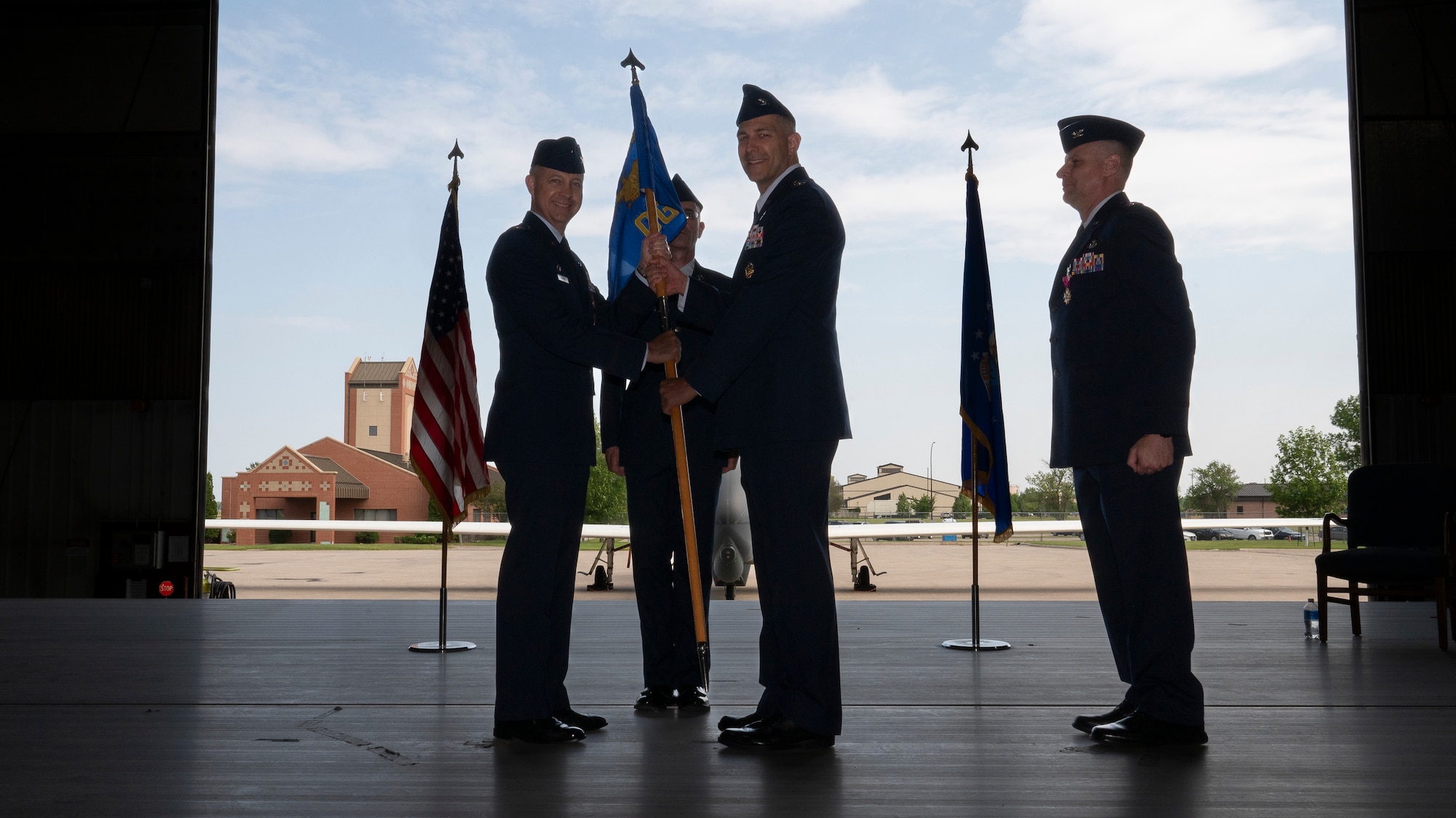 Col. Timothy Monroe, 319th Reconnaissance Wing commander, passes the guidon to Col. Brandon Cieloha, 319th Operations Group incoming commander, during the 319th OG change of command ceremony at Grand Forks Air Force Base, N.D., June 13, 2025.