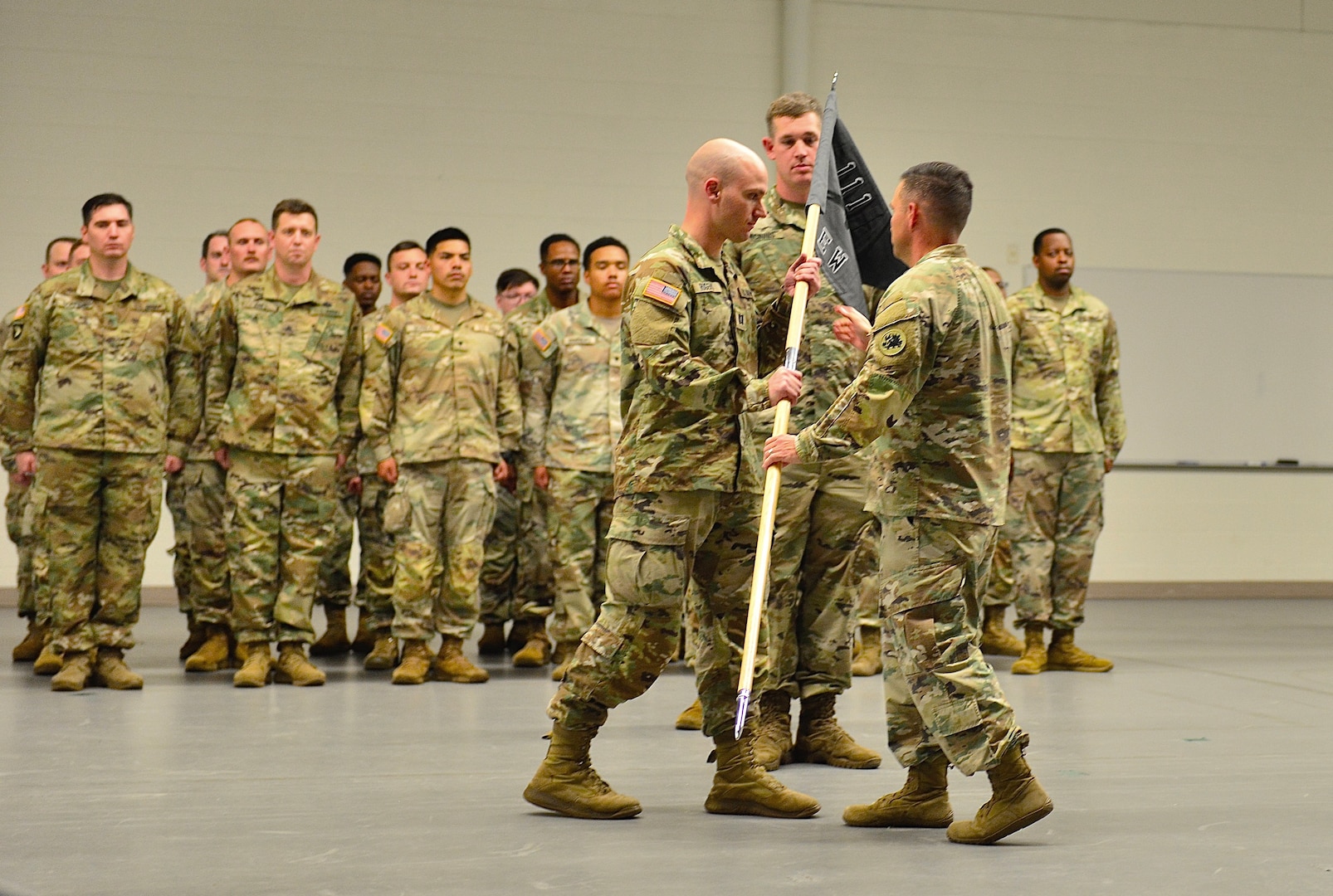 Captain Caleb D. Rogers, commander of the 111th Electromagnetic Warfare Company receives the recently uncased unit guidon from Lt. Col.  Luke E. Gurley, commander of the 221st Intelligence and Electronic Warfare Battalion, assuming his new role as commander during the company's activation ceremony June 7, 2025 in Forest Park, Ga. (U.S. Army photo by Charles A. Emmons)