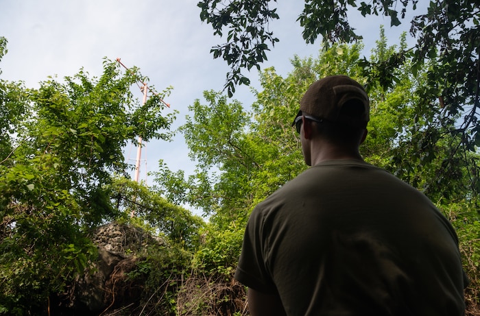 Senior Airman Skylar Ackley, 22nd Civil Engineer Squadron explosive ordnance disposal technician, surveys an approach light on the shoreline of a creek during a bank revetment project June 11, 2025, at McConnell Air Force Base, Kansas. Ackley volunteered to help with the project, which used trees to stabilize the bank and prevent erosion that was threatening the infrastructure of the approach lights on the southern tip of McConnell. (U.S. Air Force photo by Staff Sgt. Tryphena Mayhugh)