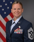 CMSgt Karissa L. Gunter poses for an official photo with an American flag in the background.