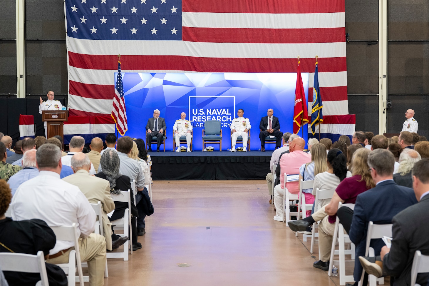 Outgoing Commanding Officer Capt. Jesse Black speaks during the U.S. Naval Research Laboratory (NRL) change of command ceremony, Washington, D.C., June 13, 2025. Joining him on stage are NRL’s Director of Research Dr. Bruce Danly, Chief of Naval Research Rear Adm. Kurt Rothenhaus, and incoming Commanding Officer Capt. Randy C Cruz. (U.S. Navy photo by Sarah Peterson)