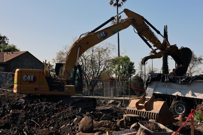 A contractor with the U.S. Army Corps of Engineers collects debris at a home in Altadena, California, April 6.