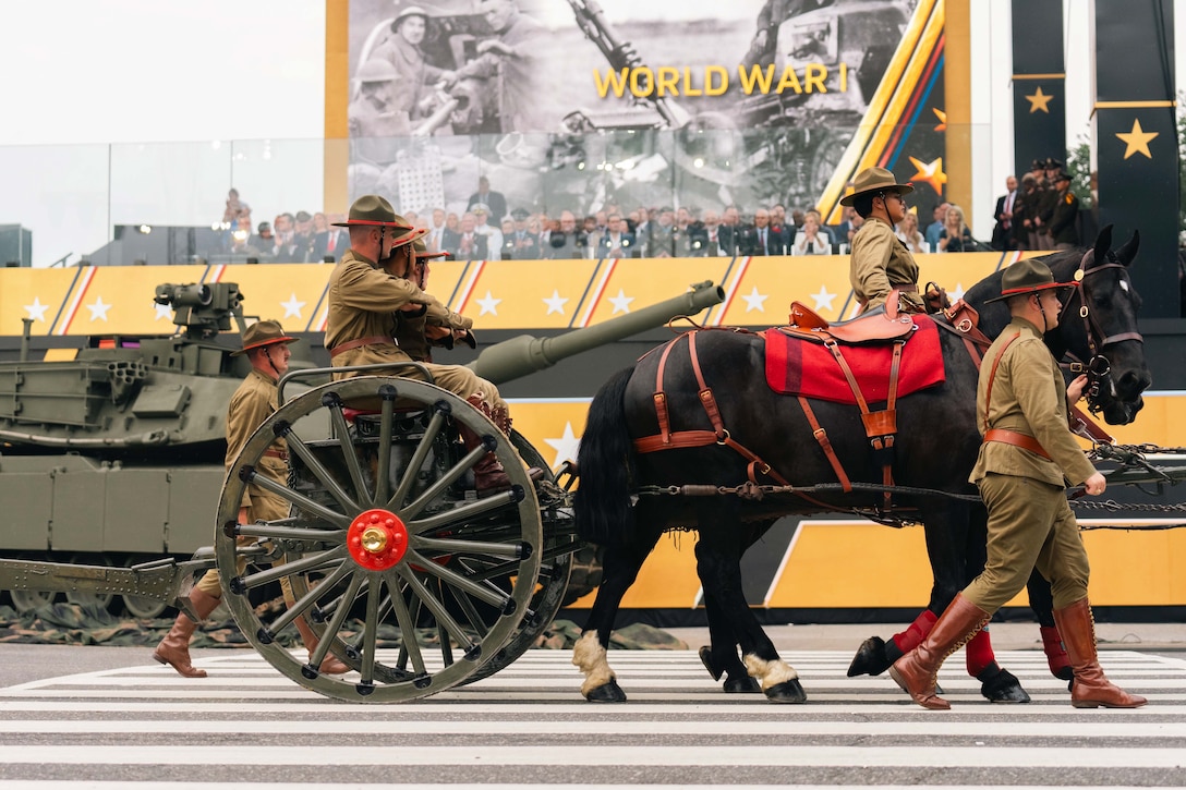 Soldiers in ceremonial dress march near horses and a tank in a parade as spectators watch.
